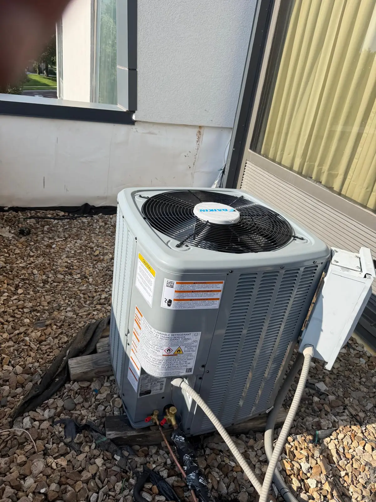 Daikin outdoor condenser unit installation on gravel bed